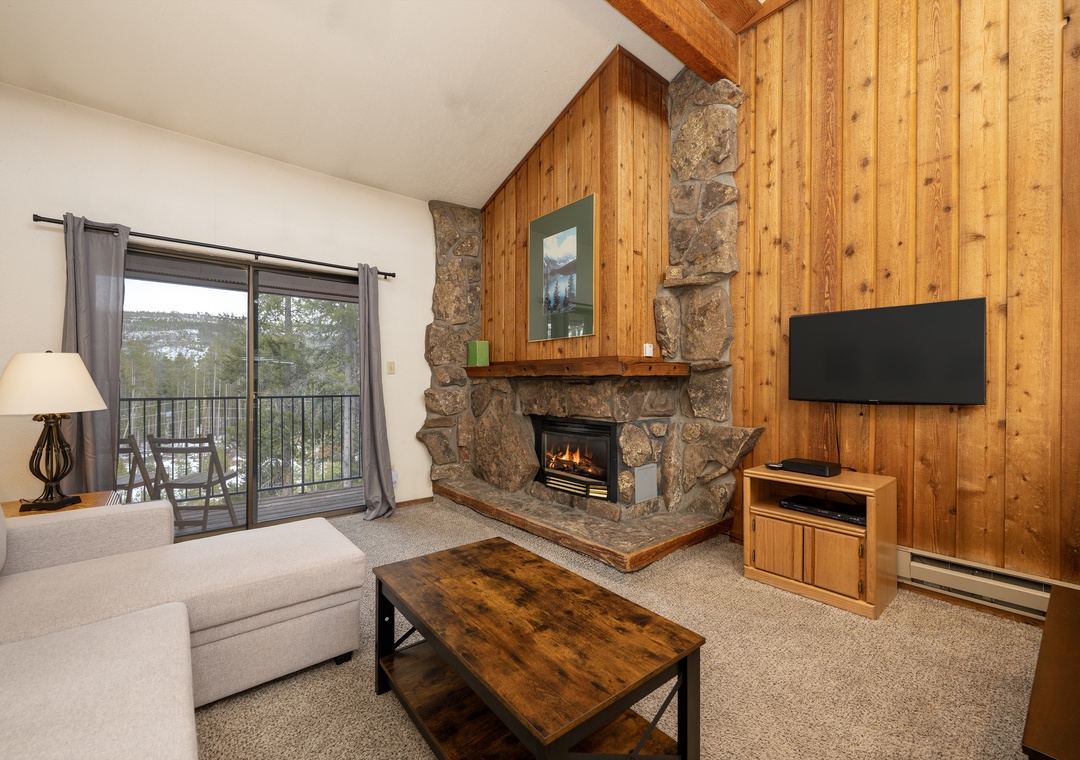 Cozy up in your mountain retreat with a crackling stone fireplace, warm wood accents, and peaceful valley views from your private balcony.