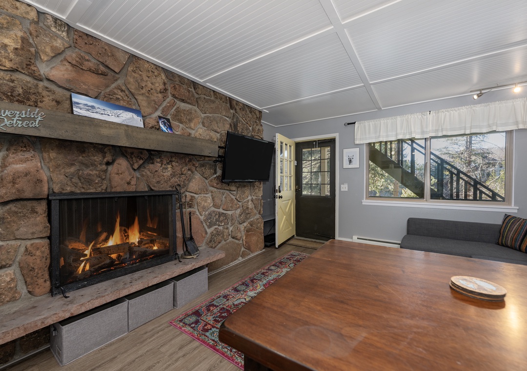 Cozy up by your crackling stone fireplace while watching TV in this inviting living space with rustic charm.