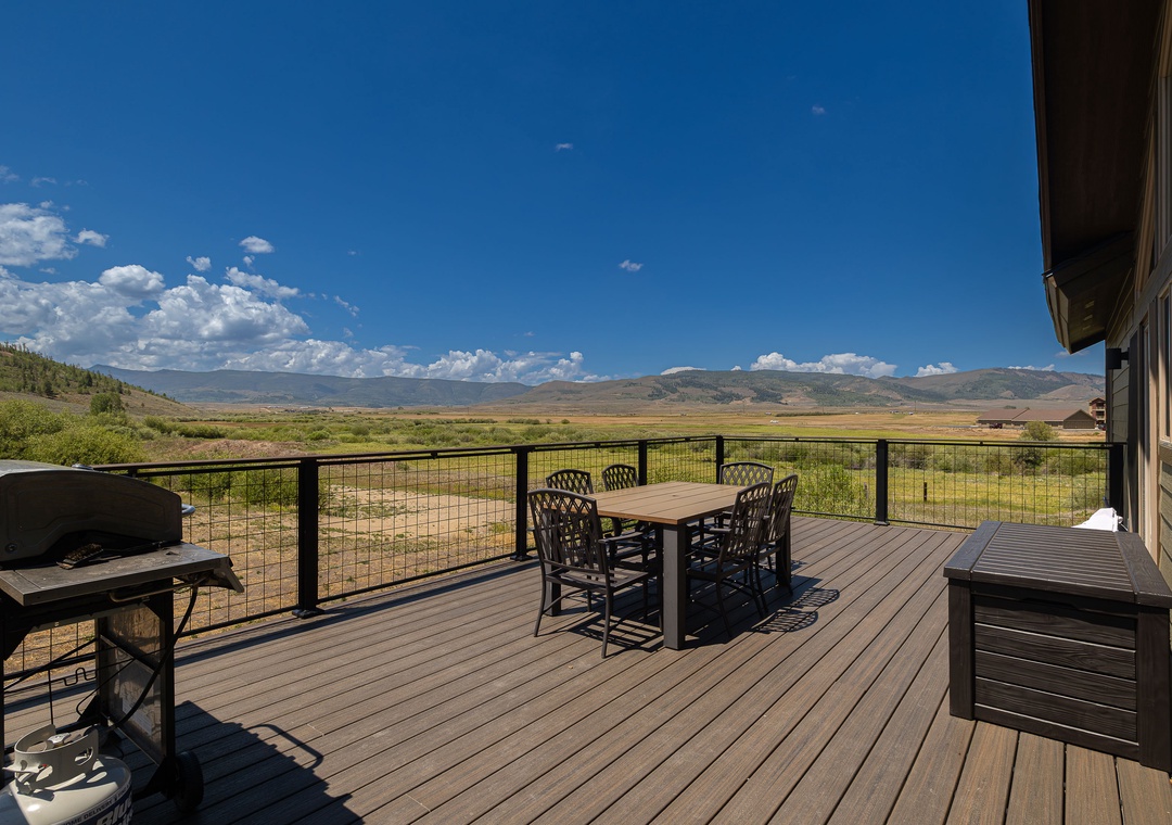 A sweeping mountain valley panorama unfolds from this spacious deck, where morning coffee at the outdoor dining table and evening barbecues become your daily ritual.