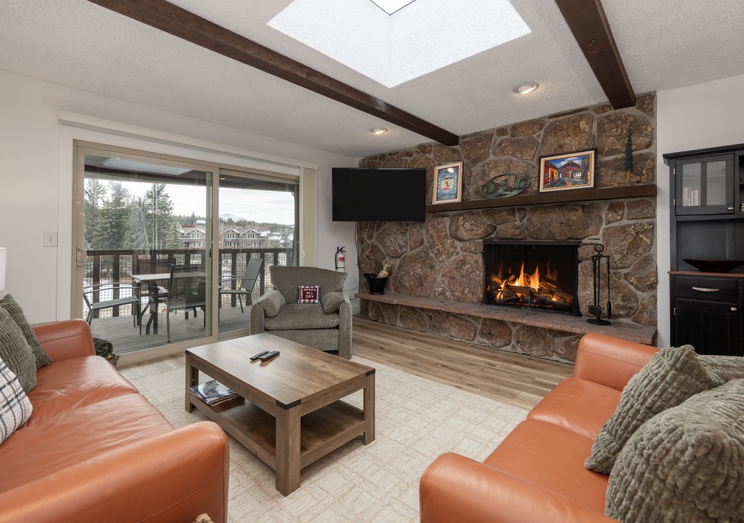 Cozy up by your crackling stone fireplace while soft light streams through the skylight above your comfortable leather seating area.