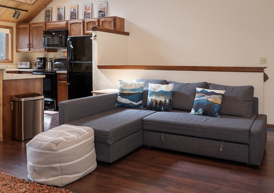 Relax in your cozy living space with mountain-themed pillows and natural wood details that create the perfect home away from home.