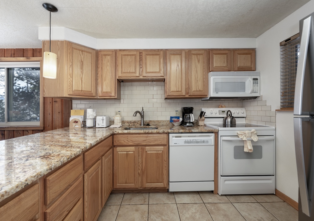 Your fully equipped kitchen features warm wood cabinets, granite countertops, and modern appliances for all your culinary needs.