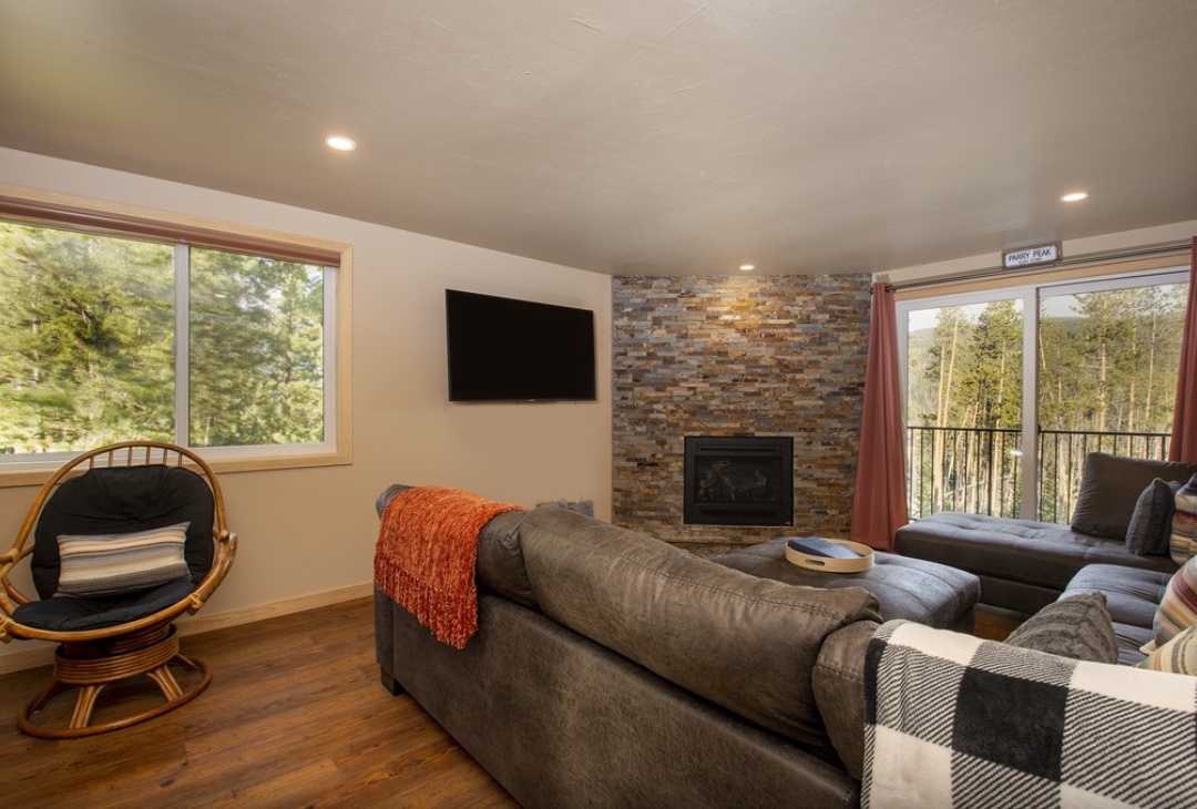 Cozy up by your stone fireplace while forest views surround this bright, modern retreat.