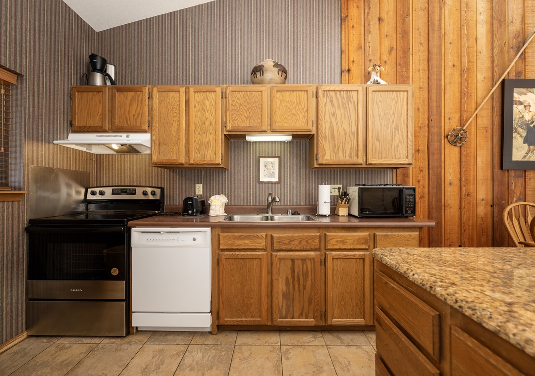 Your fully equipped kitchen features warm wood cabinetry, granite counters, and everything you need to prepare meals during your stay.