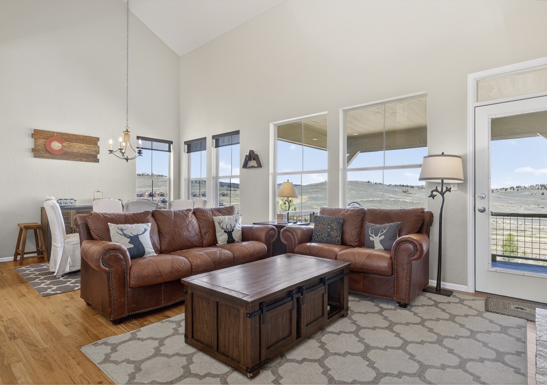 Sink into rich leather sofas and enjoy panoramic mountain views through floor-to-ceiling windows in your bright, welcoming living space.