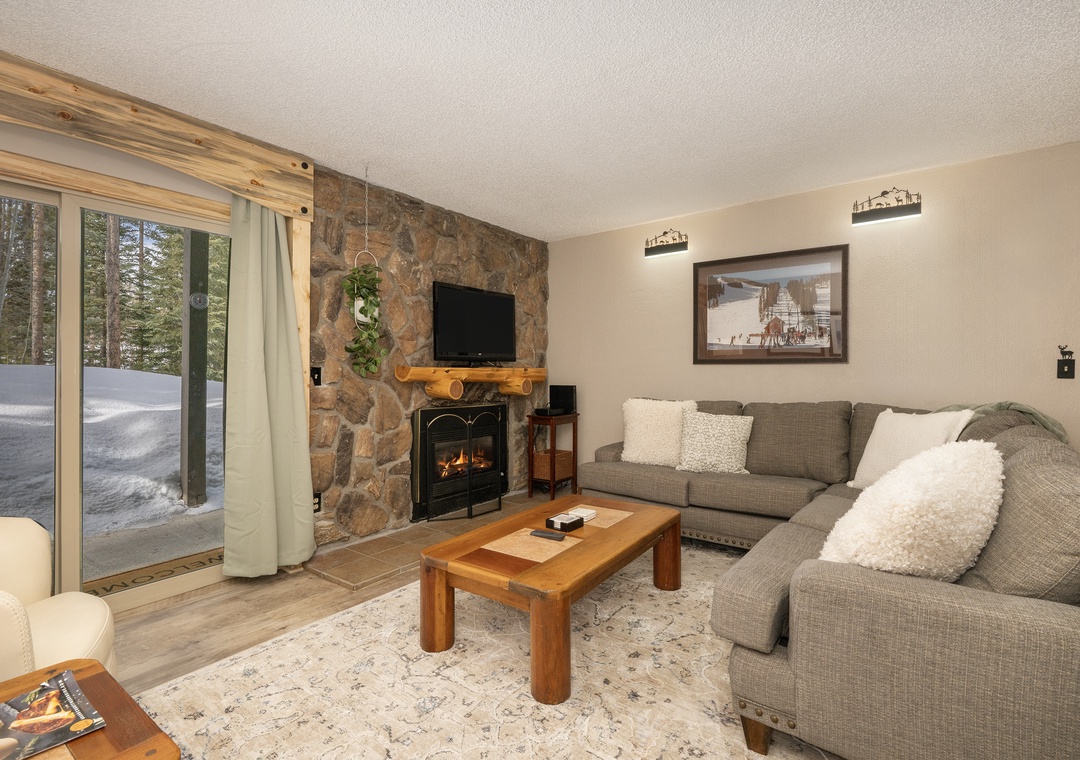 Cozy up in your alpine retreat where the stone fireplace crackles warmly and plush seating invites relaxation after snowy mountain adventures.