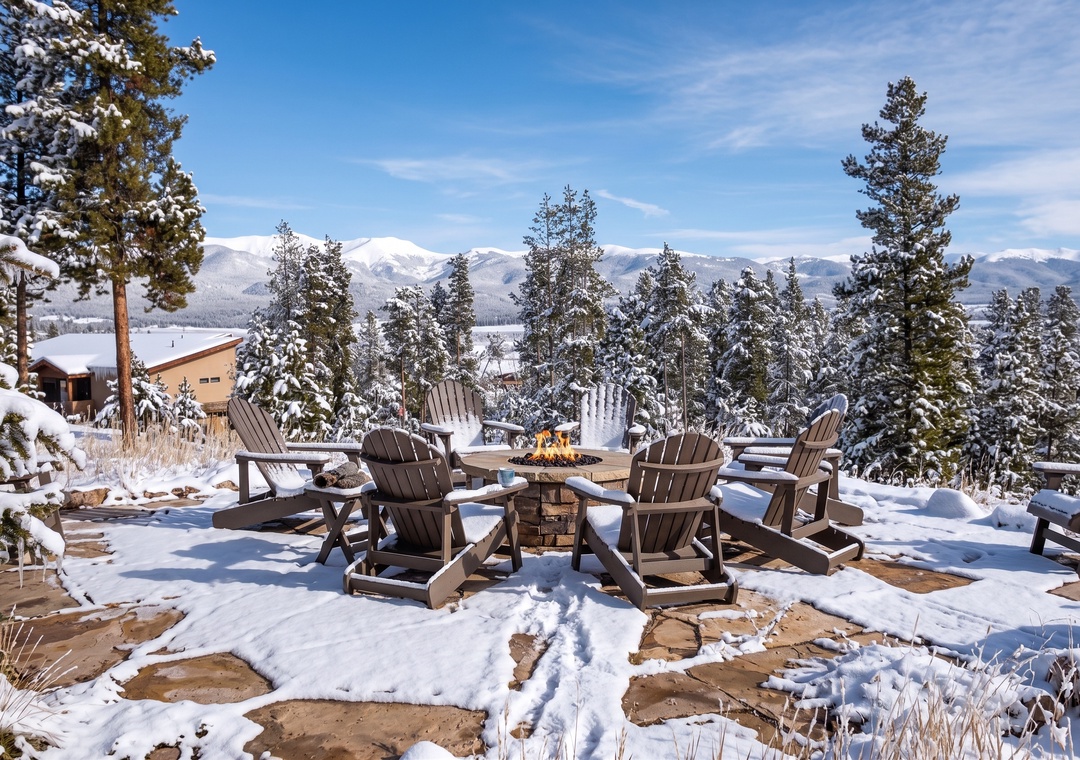 Gather around the crackling fire pit with stunning alpine views, where snow-dusted chairs await cozy evenings under clear mountain skies.