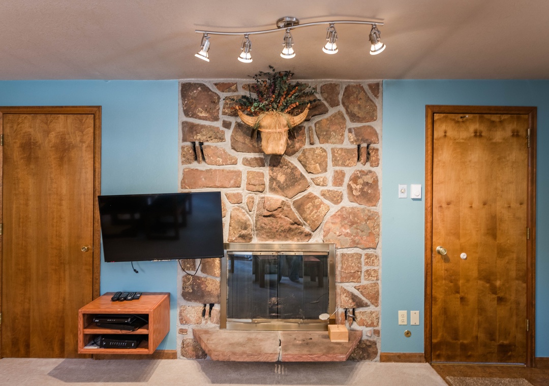 Cozy up by the beautiful stone fireplace while your favorite shows play on the flat-screen TV in this welcoming living space.