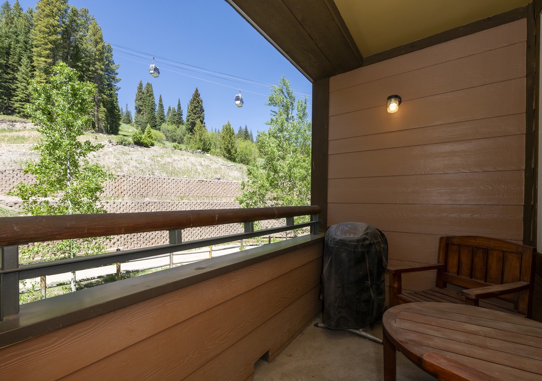 Unwind on your private balcony with sweeping mountain and forest views, where a cozy seating area invites you to soak in the fresh alpine air and watch the gondolas glide by overhead.
