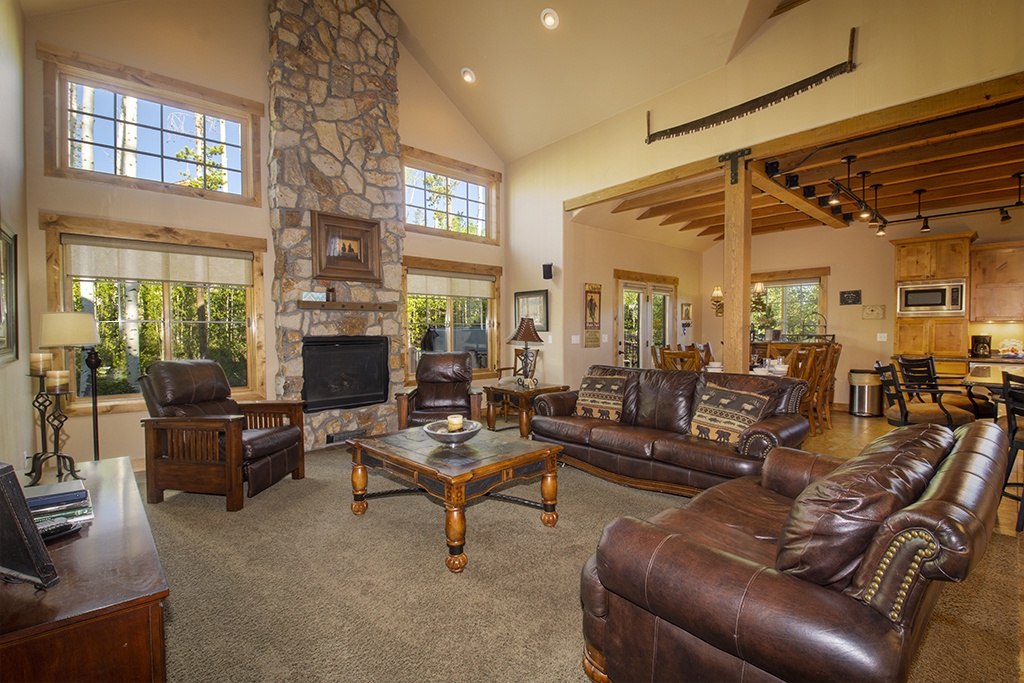 Sink into rich leather seating by your crackling stone fireplace, where soaring ceilings and warm wood create your perfect mountain retreat.