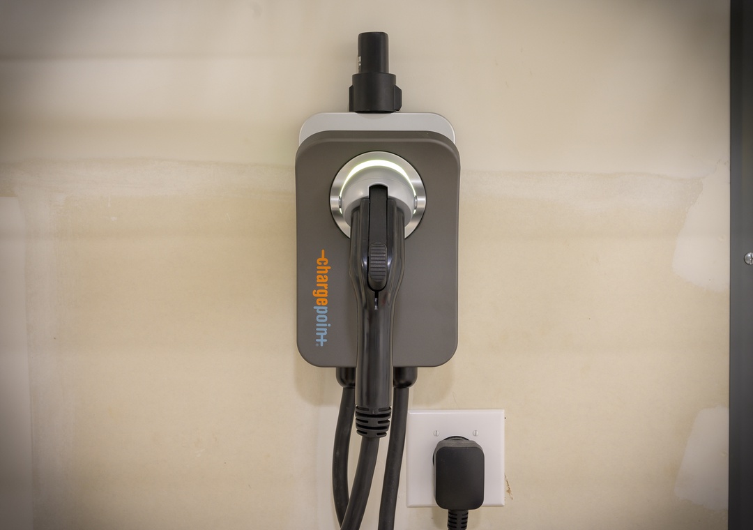 An EV charging station is mounted on the wall, ready to power your electric vehicle during your stay with convenient on-site charging access.
