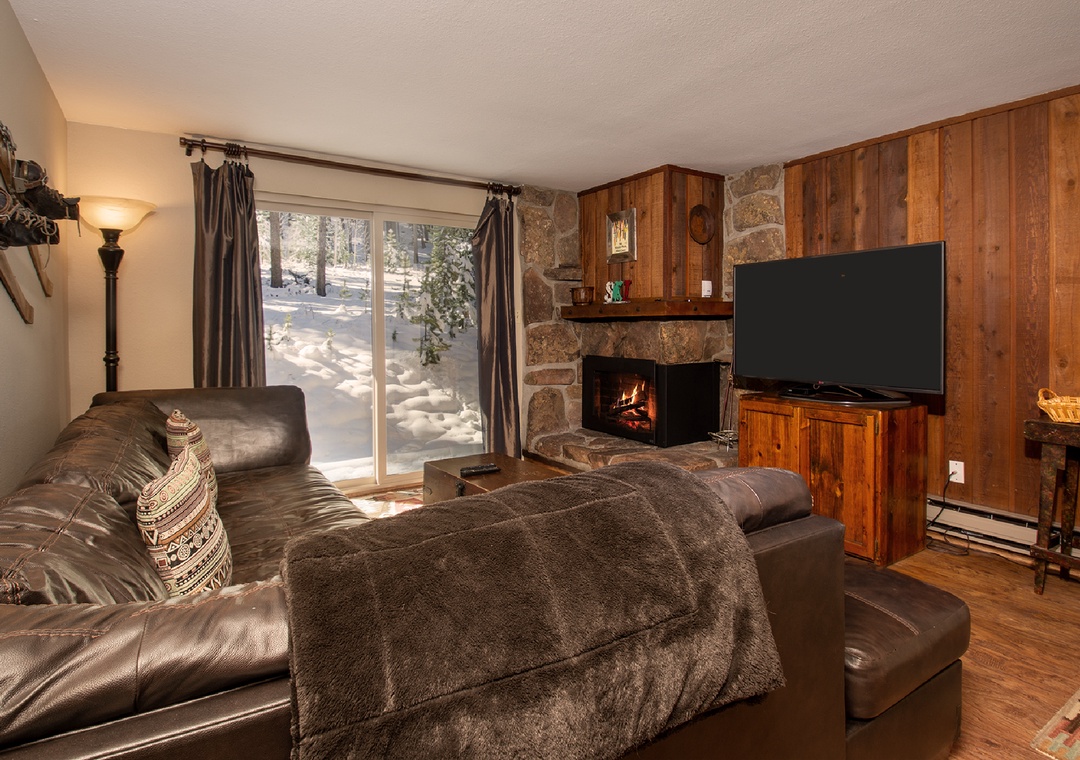 Curl up on plush leather seating by your crackling fireplace, watching snow fall through the window in this cozy mountain retreat.