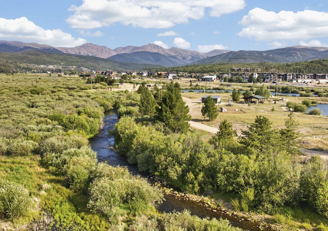 Aerial view showing the property's mountain setting, with a winding river through natural landscape and residential development in the surrounding area.