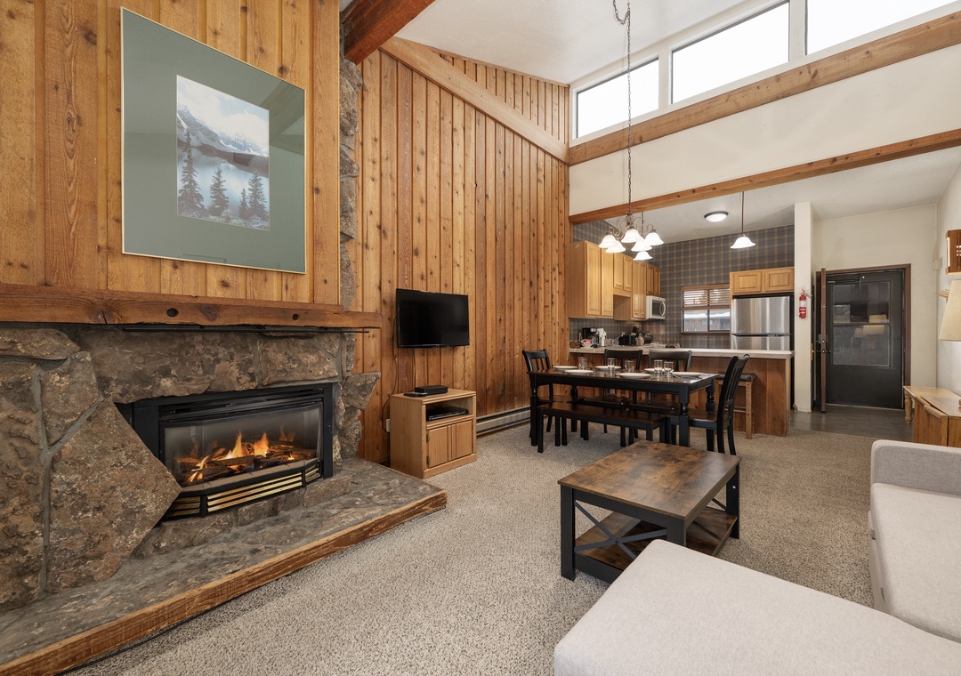 Cozy up by your crackling stone fireplace in this warm living space, where vaulted ceilings and rustic wood create the perfect mountain retreat.