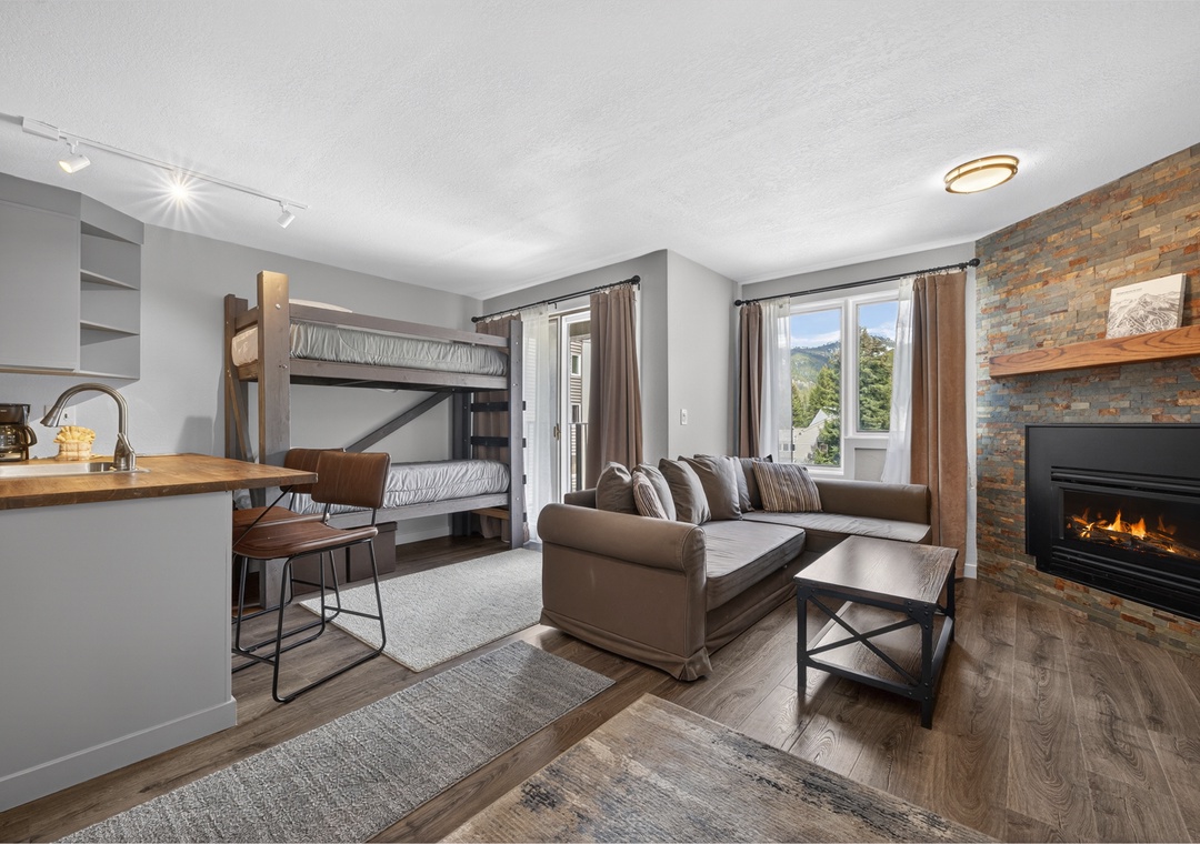 Unwind in your cozy living space featuring a warm fireplace, mountain views, and comfortable seating—perfect for family relaxation after adventurous days exploring the area.