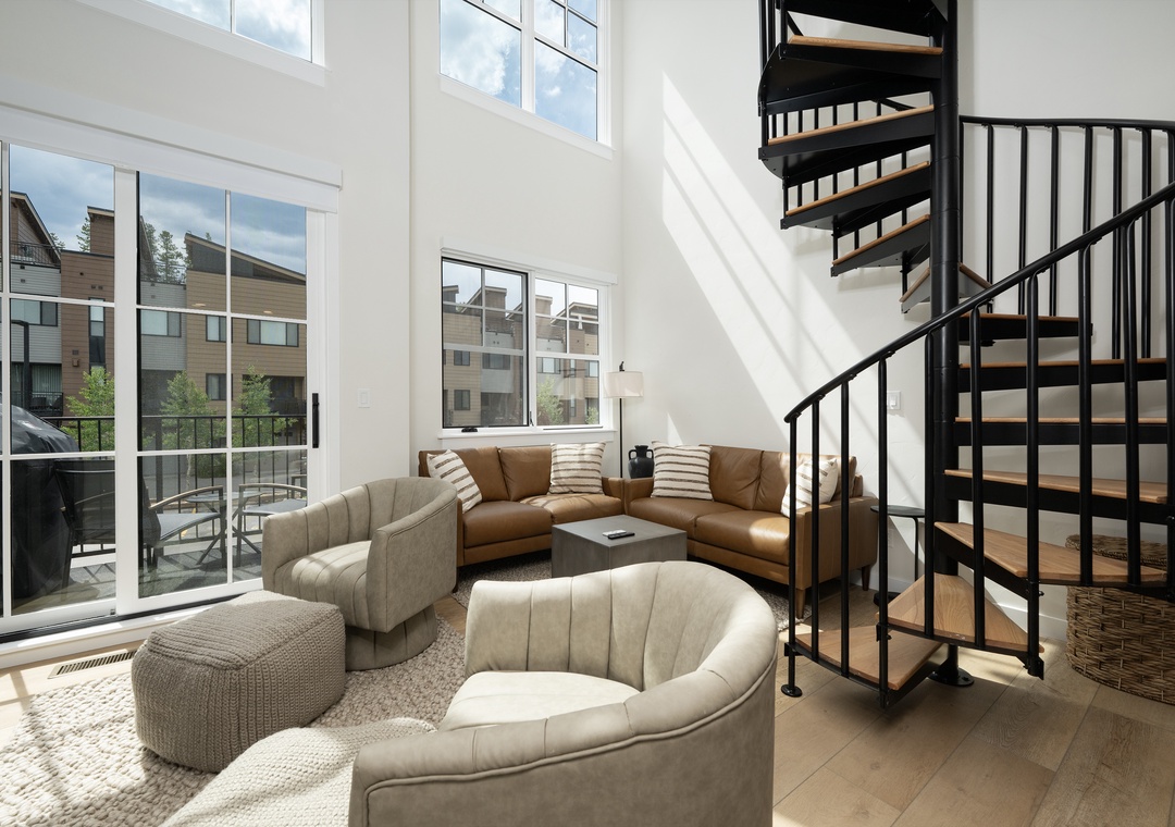 Relax in your bright living space with stylish curved seating and a striking spiral staircase leading to your private upper level.