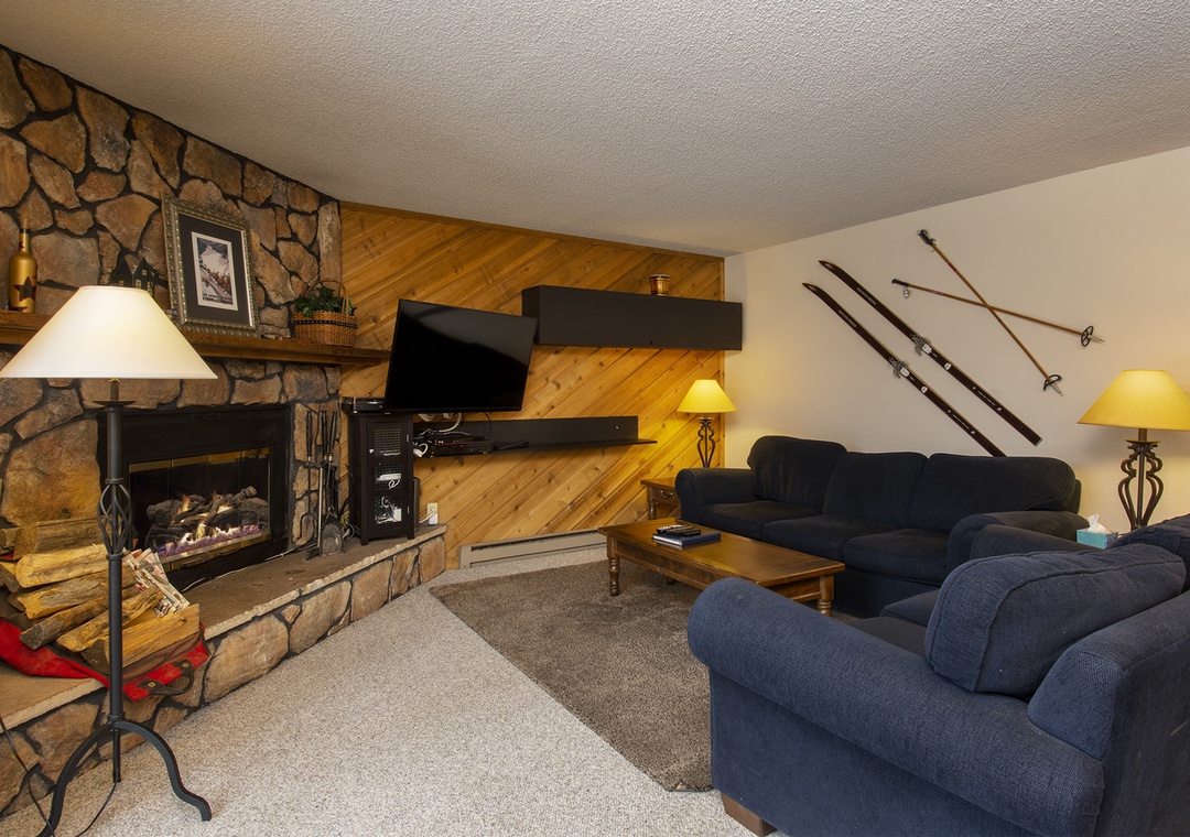 Cozy up by the stone fireplace after your mountain adventures, with comfortable seating and rustic charm throughout.