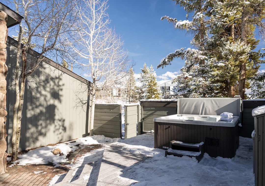 Soak in your private hot tub surrounded by snow-dusted evergreens and crisp winter air in this secluded outdoor retreat.