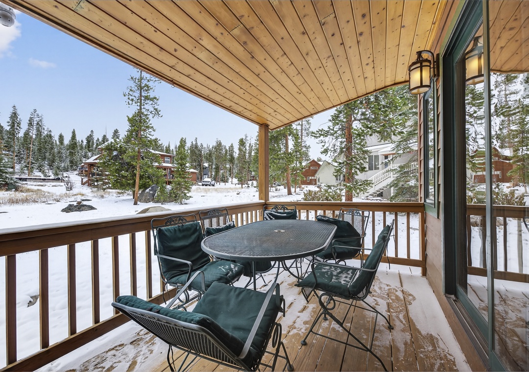 Cozy covered balcony with dining seating overlooking snowy winter forest views—your perfect mountain retreat spot at 21 GCR 4435.