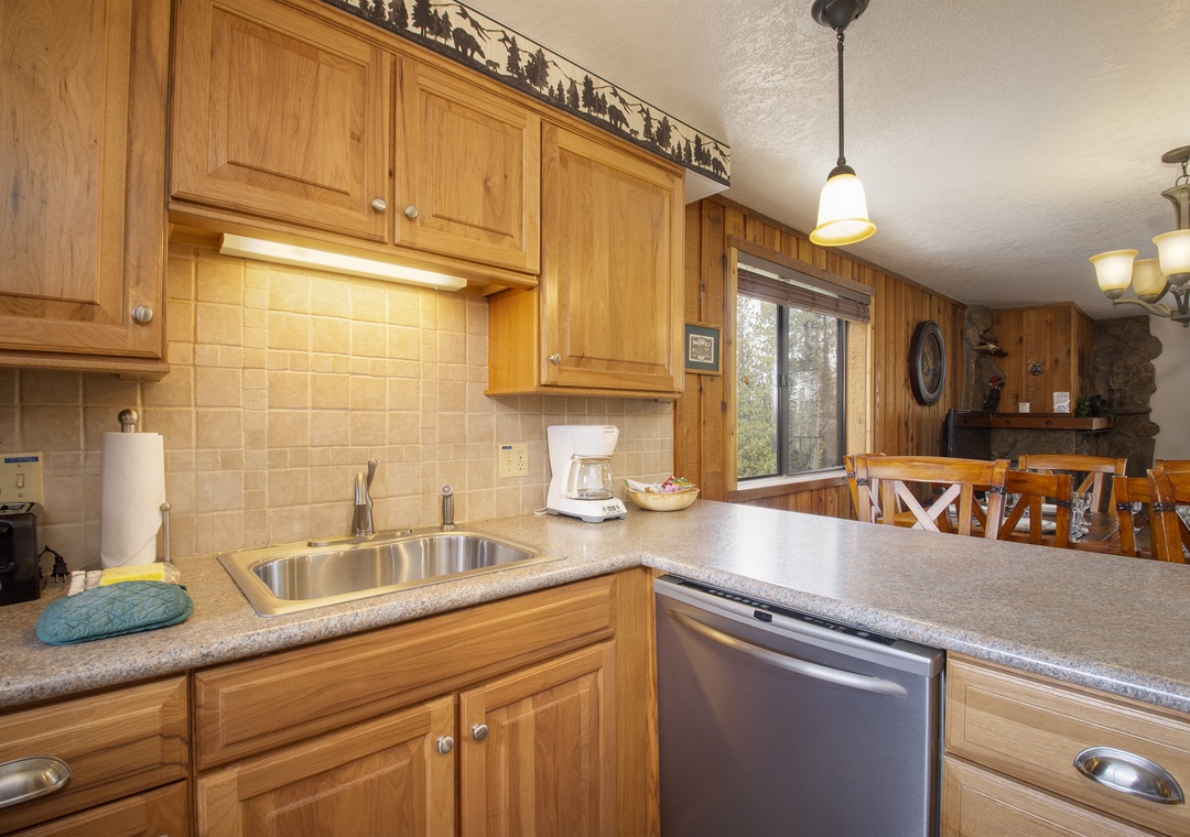 Your fully equipped kitchen features warm wood cabinets, granite countertops, and stainless steel appliances, creating the perfect space for preparing meals during your stay.