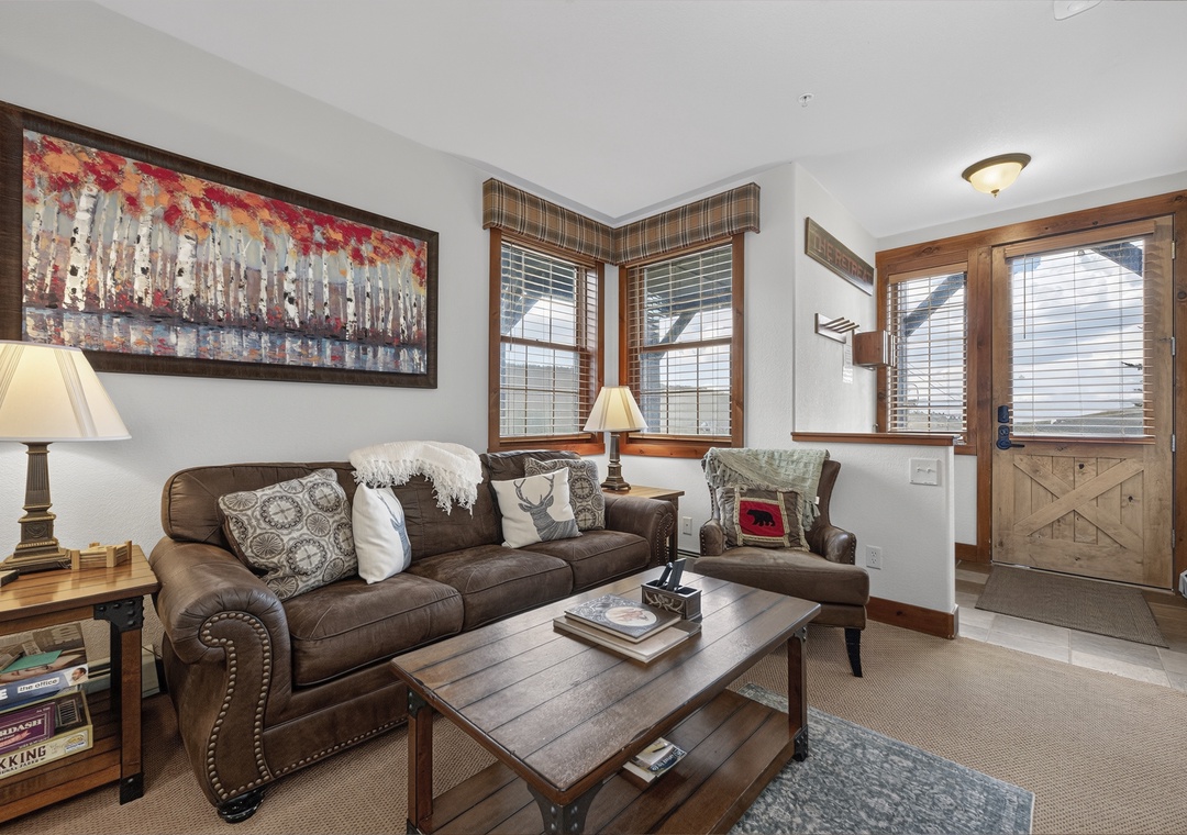 Settle into your cozy living room, where plush seating and warm wood accents invite you to unwind after a day of adventure.