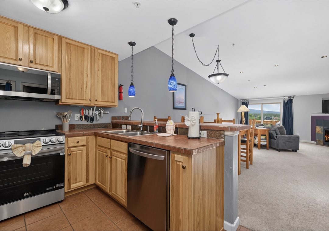 You'll love the open layout blending your fully equipped kitchen, cozy dining space, and living area—perfect for cooking together, sharing meals, and relaxing by the fire with stunning mountain views just beyond your windows.