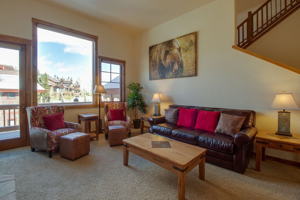 Sink into the leather sofa with colorful pillows and enjoy mountain views through large windows in your bright, inviting living space.