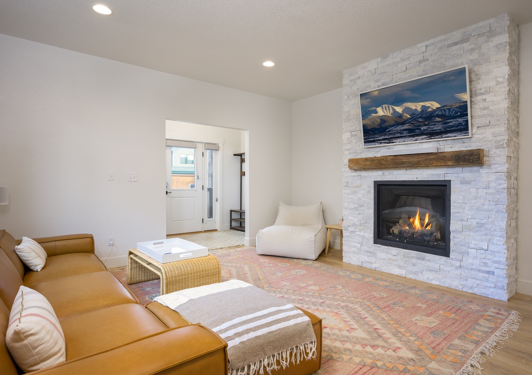 Unwind in your bright living room where a cozy fireplace and mountain artwork create the perfect retreat for relaxing evenings after your alpine adventures.
