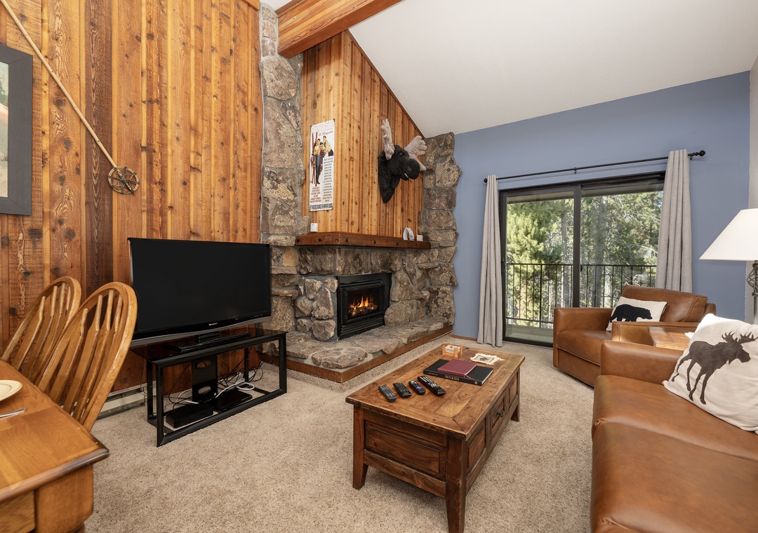 Cozy up in your mountain retreat with rustic wood walls, a crackling stone fireplace, and leather seating perfect for relaxing evenings.