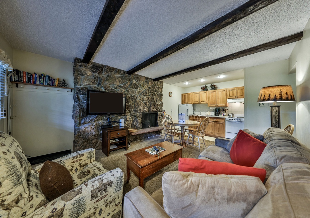 Sink into plush sofas by your stone fireplace, where rustic beams and mountain charm create the perfect retreat for cozy evenings.