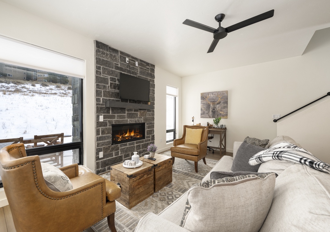 Cozy up by your crackling fireplace at Base Camp Townhome 106 while watching snow fall outside your window, creating perfect winter retreat moments.
