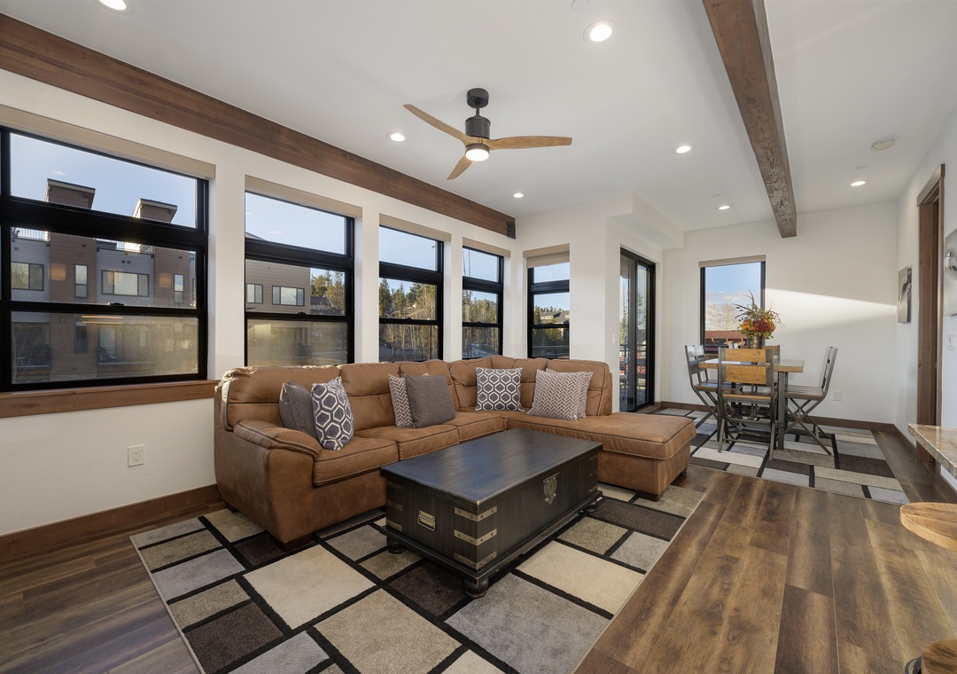 Sink into your plush sectional sofa while enjoying mountain views through expansive windows in this bright, modern living space.