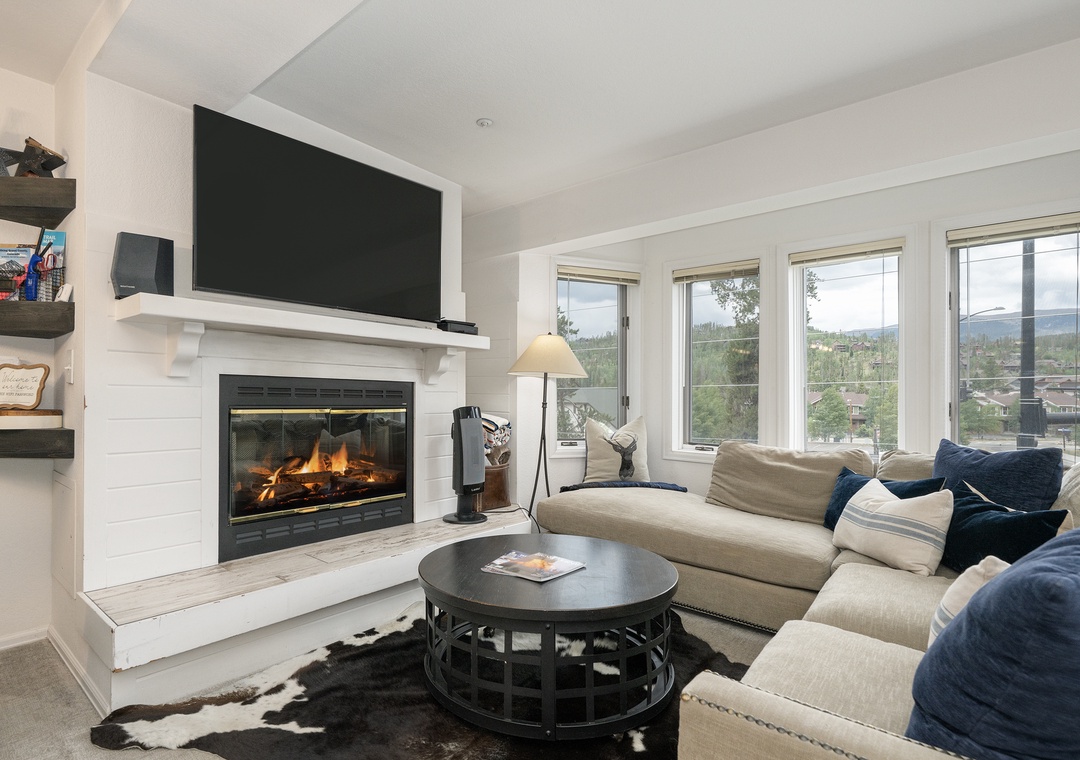 Cozy up by your crackling fireplace while mountain views frame your perfect retreat through panoramic windows.