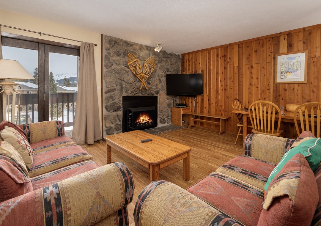 Cozy up in your rustic living room where a crackling fireplace and mountain views create the perfect après-ski retreat.