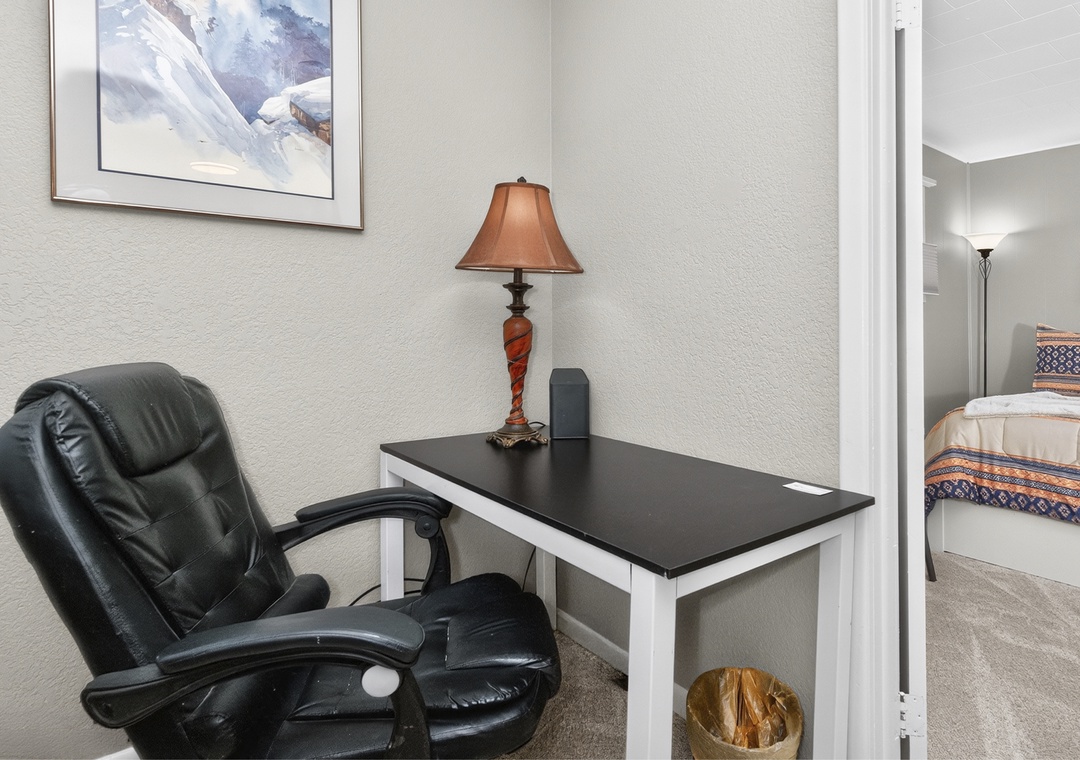 A quiet corner awaits your thoughts—settle into the plush chair and let work or reflection flow naturally at your private desk.