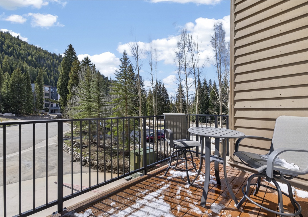 Enjoy morning coffee on your private balcony with mountain and forest views. A small bistro table and chairs create the perfect spot to plan your day's adventures.