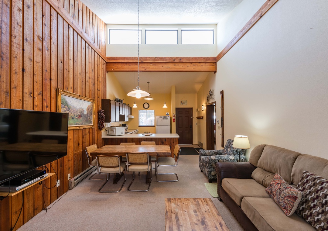 Unwind in your cozy retreat with soaring ceilings, warm wood accents, and a perfect blend of living, dining, and kitchen spaces for memorable moments.
