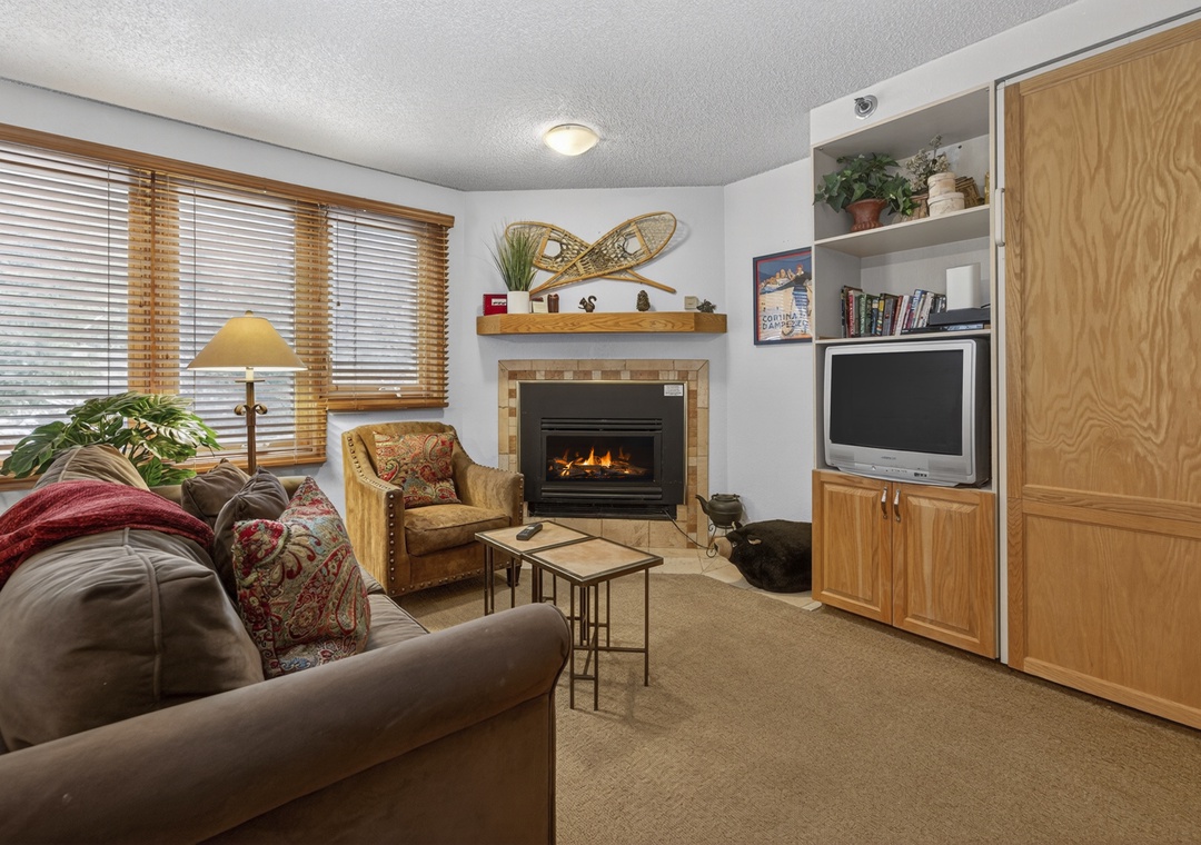 Curl up in your cozy living room with plush seating, a warm fireplace, and entertainment center—perfect for relaxing evenings after mountain adventures.
