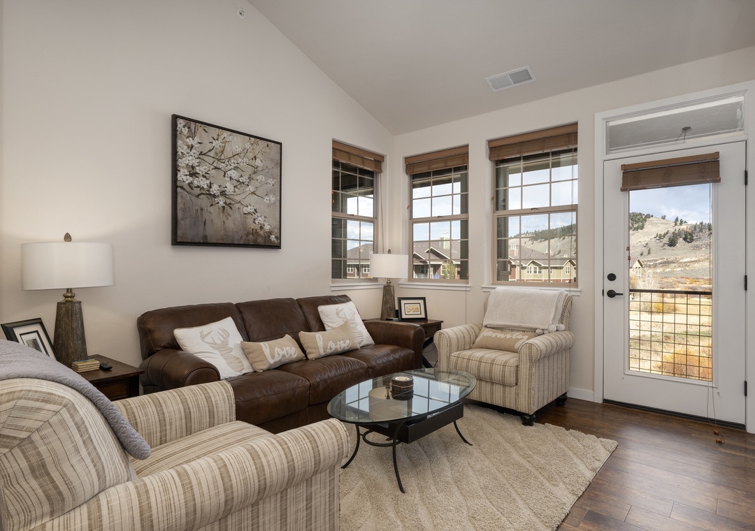 Settle into your cozy living space with plush seating and stunning mountain vistas through oversized windows.