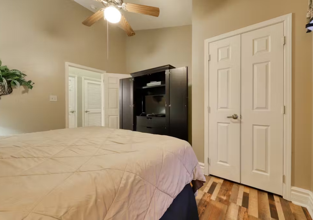 Your cozy bedroom features warm hardwood floors, convenient built-in entertainment center, and ceiling fan for perfect comfort during your stay.