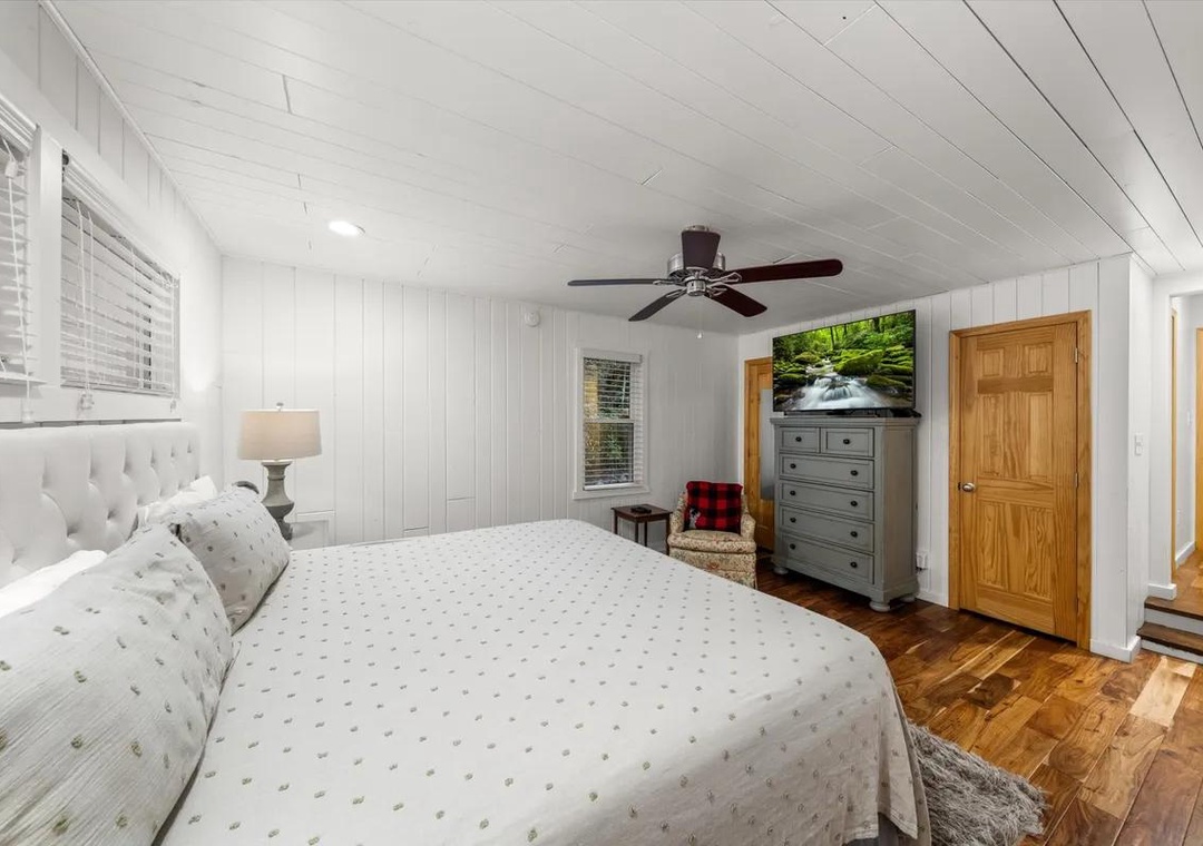 Slip into crisp linens and feel the gentle breeze from the ceiling fan as you unwind in your private retreat with warm wood floors and soft natural light.