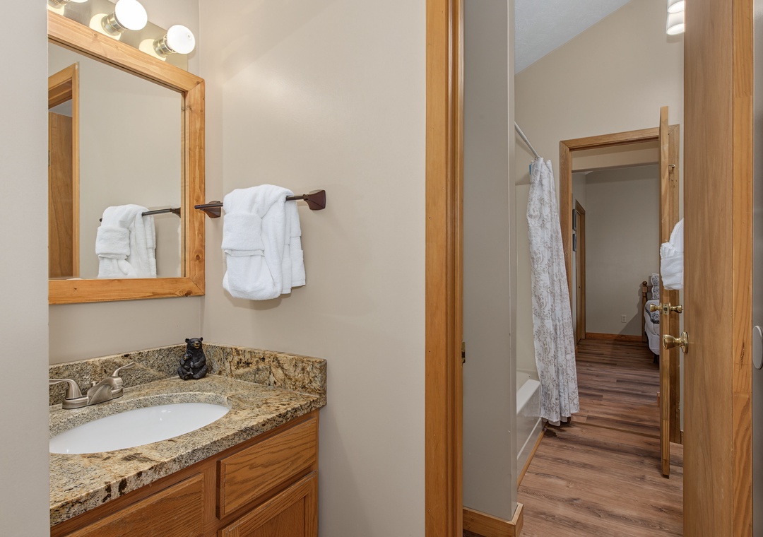 Freshen up in your private bathroom, complete with plush towels, a vanity mirror with warm lighting, and granite countertops for a touch of rustic elegance.