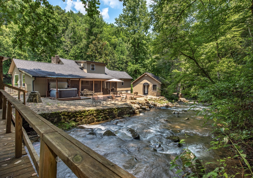 Nestled along a babbling creek beneath lush forest canopy, this peaceful retreat offers your own private hot tub, spacious patio seating, and the soothing soundtrack of flowing water just steps from your door.