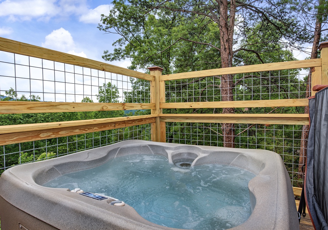 Unwind in your private hot tub on the deck, surrounded by tall pines and lush greenery—perfect for soaking under open skies after a day of adventure.