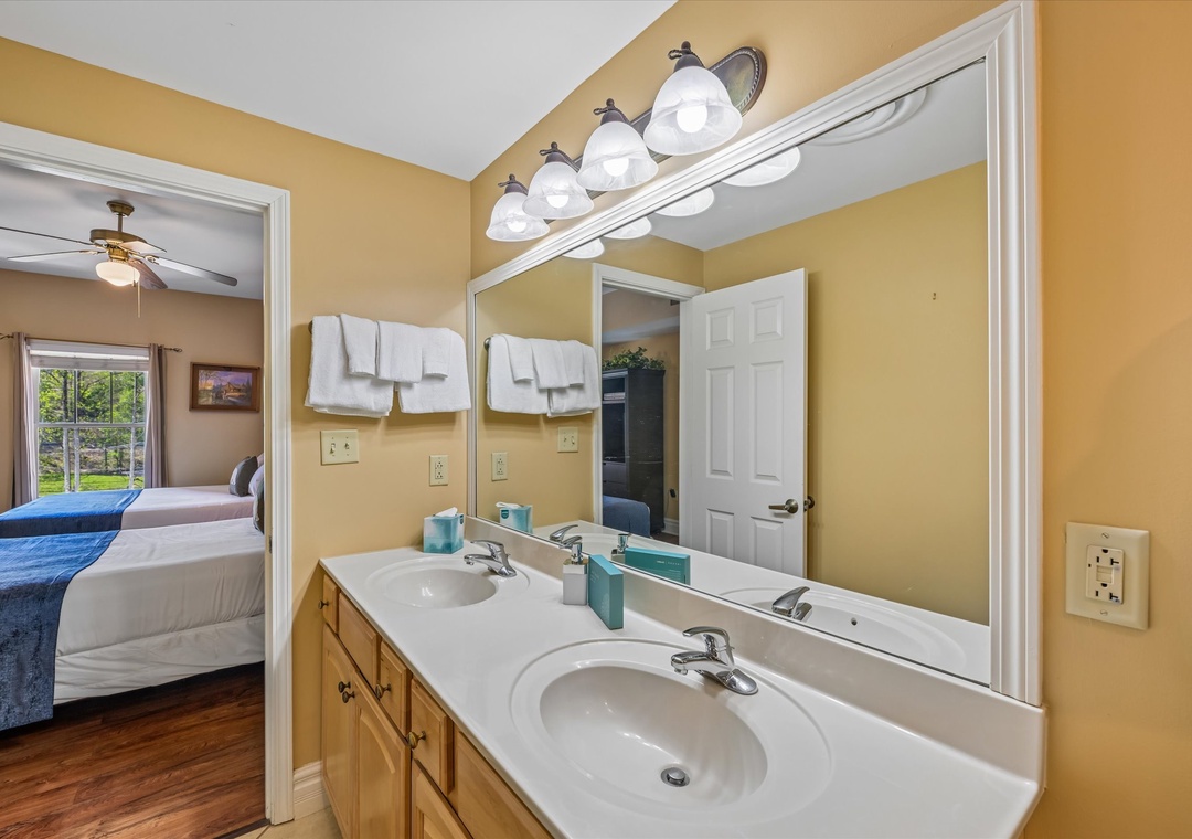 Freshen up in your private bathroom featuring dual sinks and fluffy towels, conveniently connected to your bedroom.