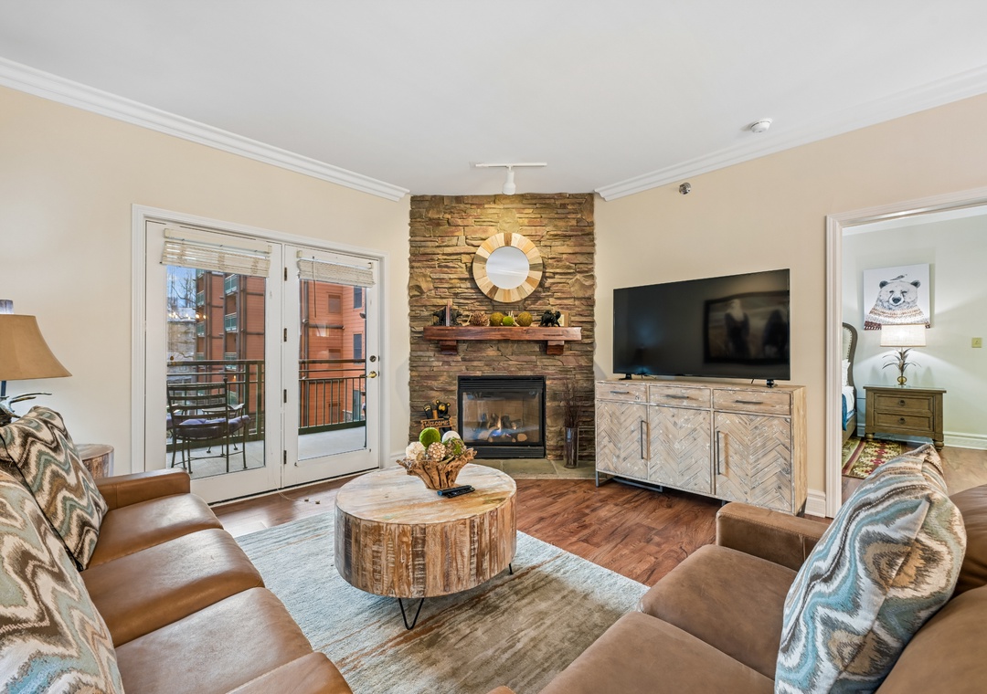 Cozy up in your beautifully appointed living room, where rustic stone fireplace meets modern comfort for perfect mountain evenings.