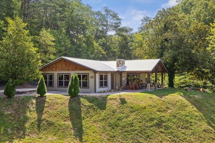 A secluded retreat nestled among towering trees, offering peaceful privacy and a covered patio where you can unwind surrounded by nature's beauty.