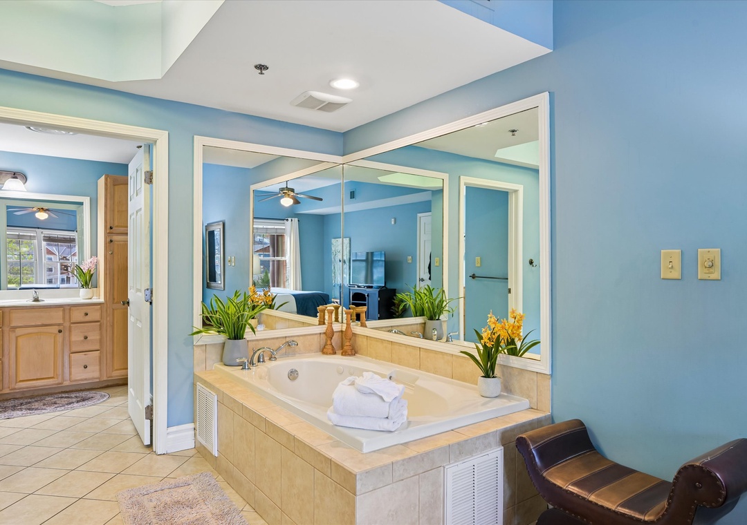 Unwind in your spa-like master suite with soaking tub, fresh flowers, and calming blue walls creating the perfect retreat.