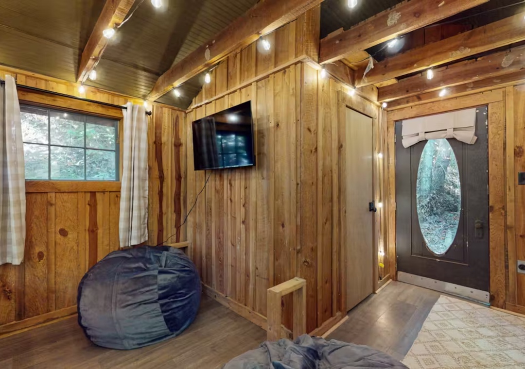 Unwind in this cozy treehouse-style retreat with twinkling fairy lights, bean bags for lounging, and a warm wooden atmosphere that feels like your personal forest hideaway.