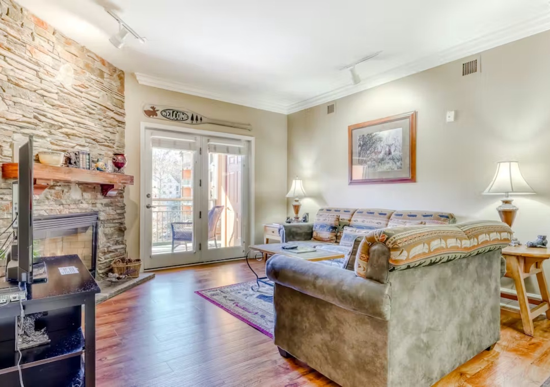 Cozy up by your stone fireplace in this warm living space, where rustic charm meets modern comfort for perfect mountain getaways.